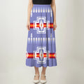 Full-length view of a woman wearing a blue, black, and white maxi dress with an eagle/thunderbird pattern.