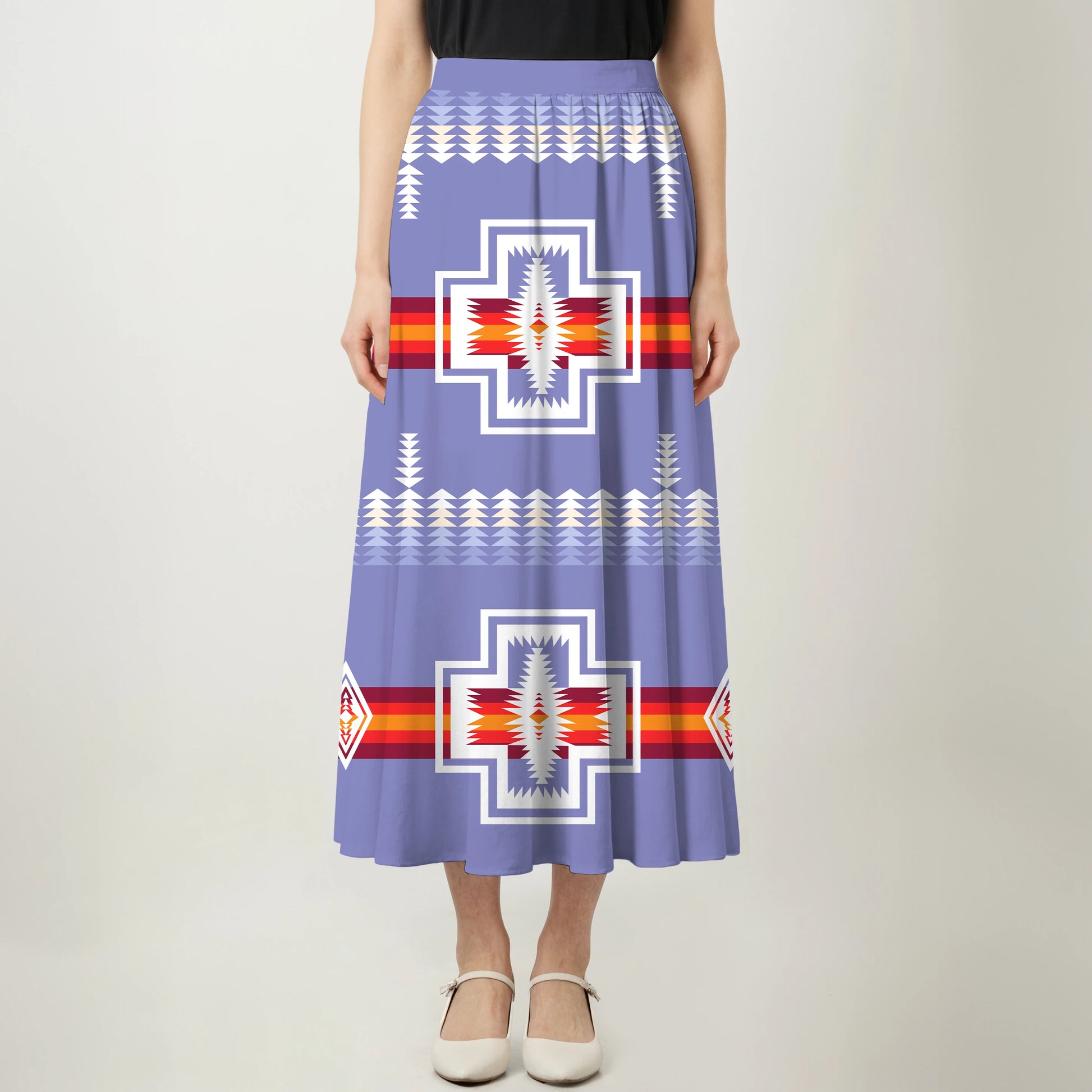 Full-length view of a woman wearing a blue, black, and white maxi dress with an eagle/thunderbird pattern.