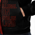 Close-up of the fleece jacket’s side design showcasing the bold text “No One Is Illegal On Stolen Land