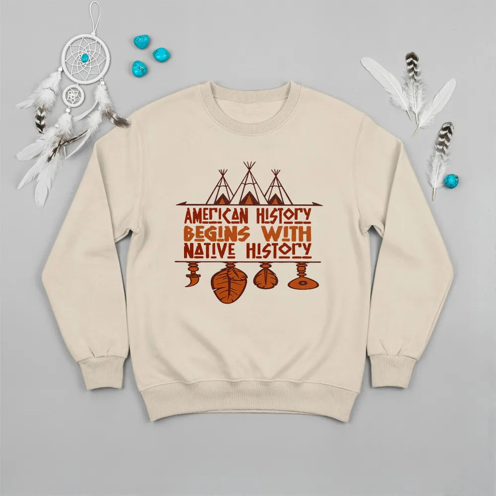 Cream crewneck sweatshirt featuring a sacred teepee and feather totem design with the quote “American History Begins with Native History.”