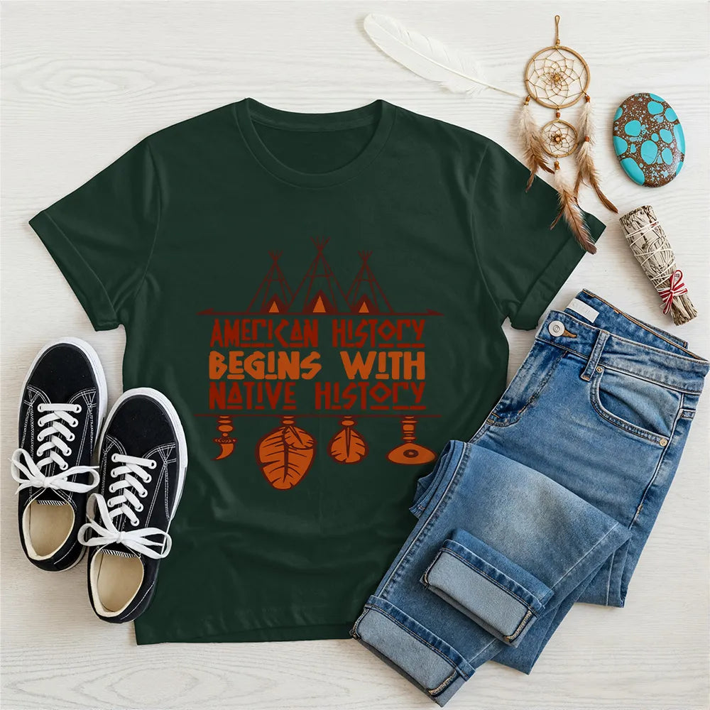 Forest green t-shirt displaying brown teepee and feather totem graphic with quote “American History Begins with Native History