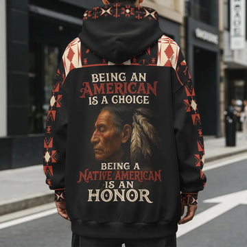 Model photographed from the back wearing a black and deep-red fleece hoodie with the bold slogan “NO ONE IS ILLEGAL ON STOLEN LAND” printed down the center