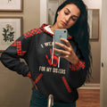 Front view of a woman taking a mirror selfie while wearing a black zip-up hoodie decorated with red tribal patterns on the shoulders and cuffs and a red handprint graphic reading “I Wear Red For My Sisters.”