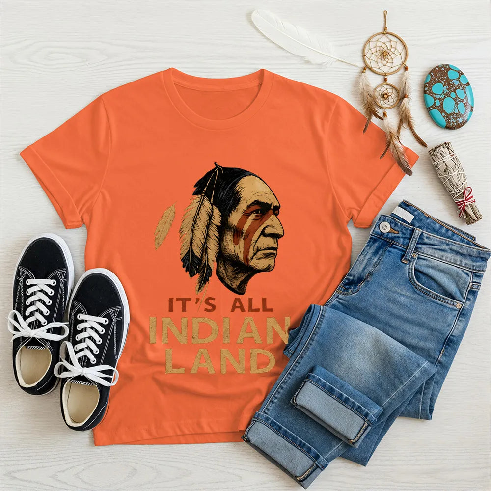 Orange "It’s All Indian Land" T-shirt with an Indigenous man and feather artwork.