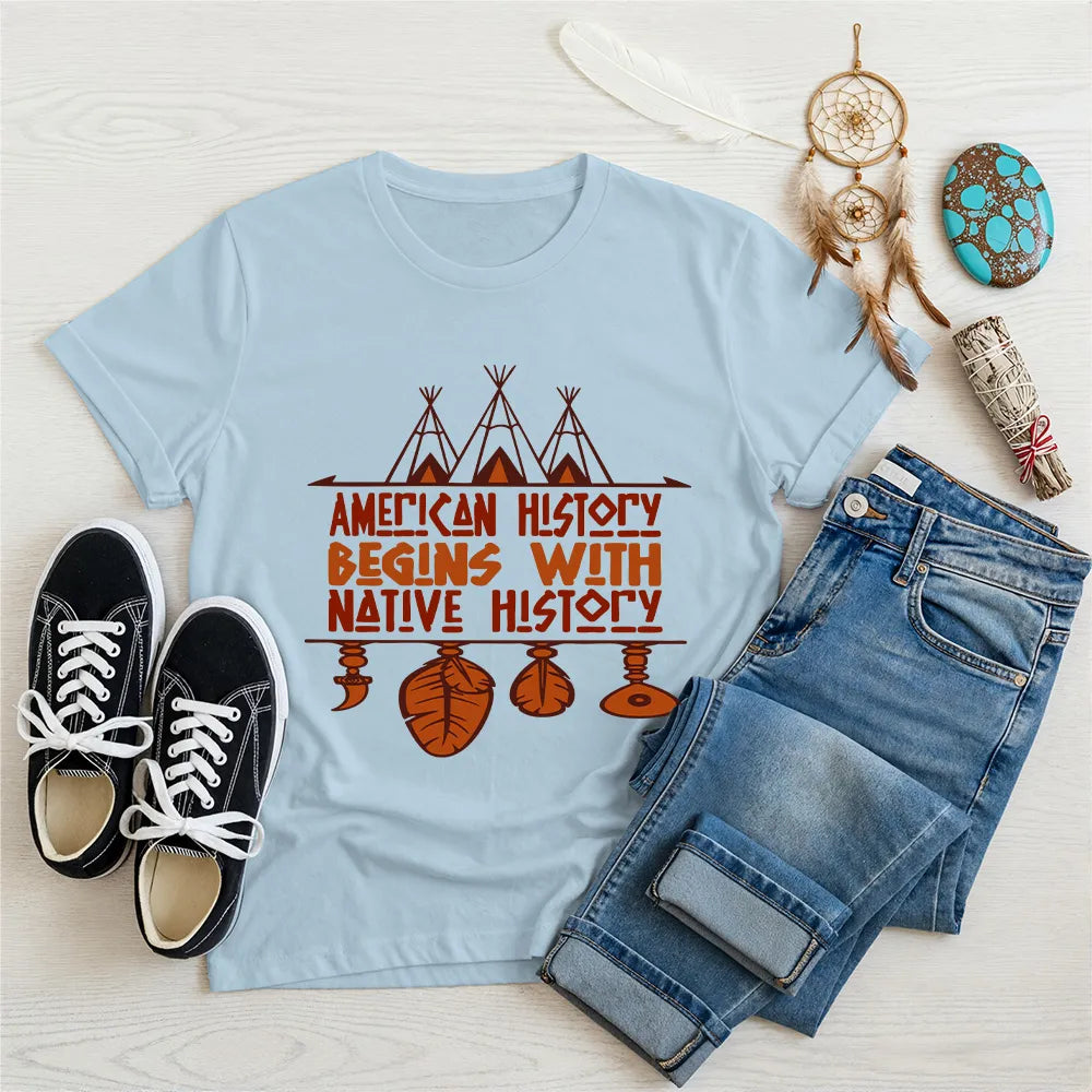 Light blue t-shirt displaying brown teepee and feather totem graphic with quote “American History Begins with Native History.
