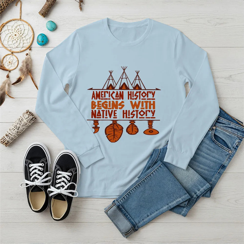 Light blue long sleeve tee featuring brown teepee and feather totem graphic with quote “American History Begins with Native History.