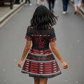 Back view of the Indigenous justice dress featuring a bold red handprint and MMIW emblem over tribal skirt pattern, model walking away