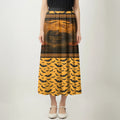 Full-length image of a woman wearing a black and orange maxi skirt. The top portion of the skirt features a 