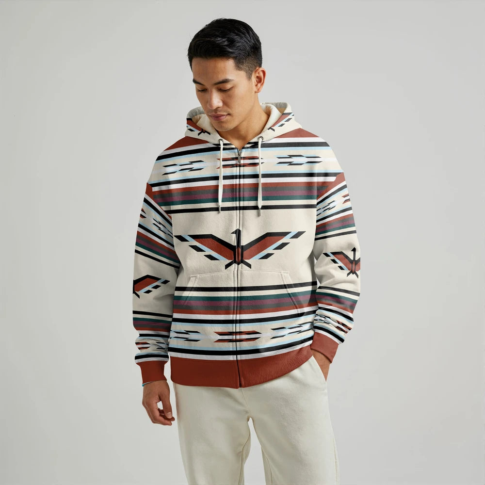 Male model wearing a cream and brown Native-American–inspired blanket hoodie with traditional stripe motifs, shown front view