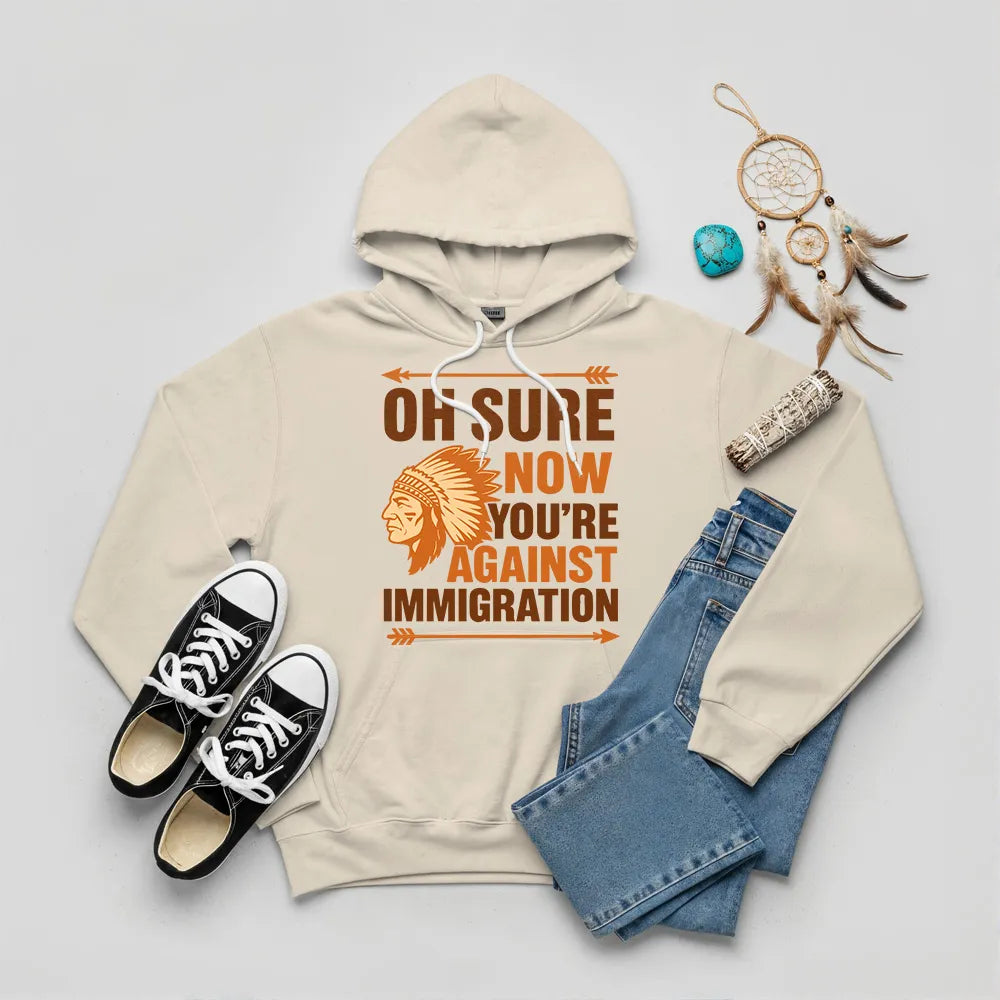 Beige hoodie featuring Native American graphic with chief headgear and the slogan 'Oh Sure Now You’re Against Immigration.'