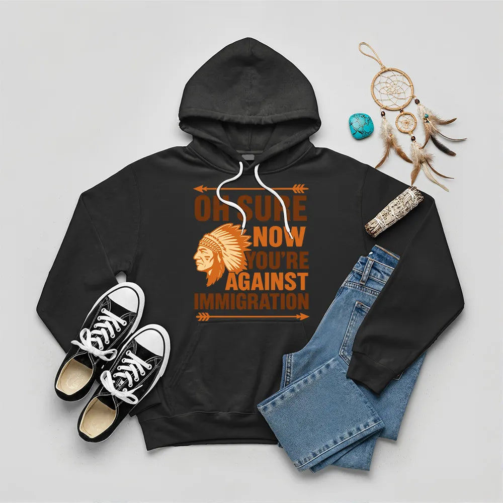 Black hoodie featuring Native American graphic with chief headgear and the slogan 'Oh Sure Now You’re Against Immigration.'