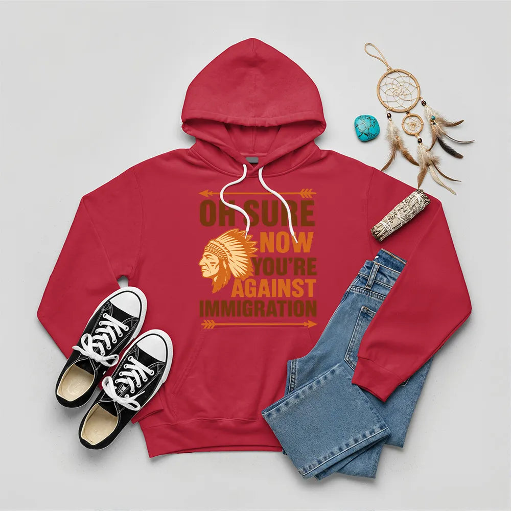 Red hoodie featuring Native American graphic with chief headgear and the slogan 'Oh Sure Now You’re Against Immigration.'