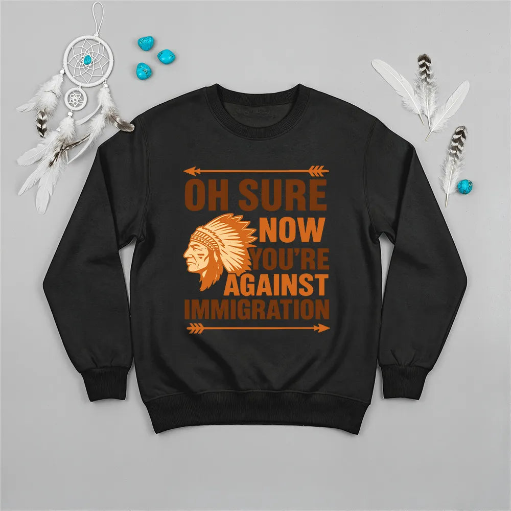 Native America graphic black sweatshirt with traditional chief headgear and 'Oh Sure Now You’re Against Immigration' text.
