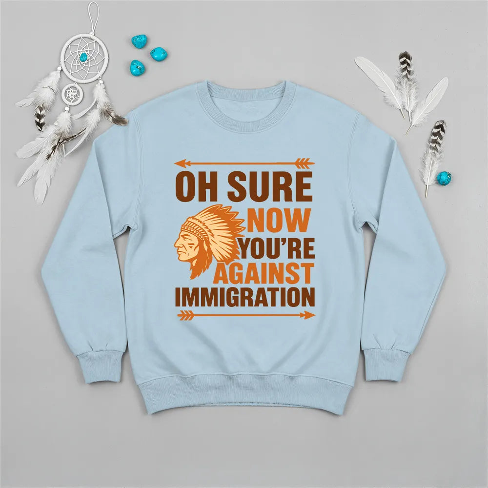 Native America graphic blue sweatshirt with traditional chief headgear and 'Oh Sure Now You’re Against Immigration' text.