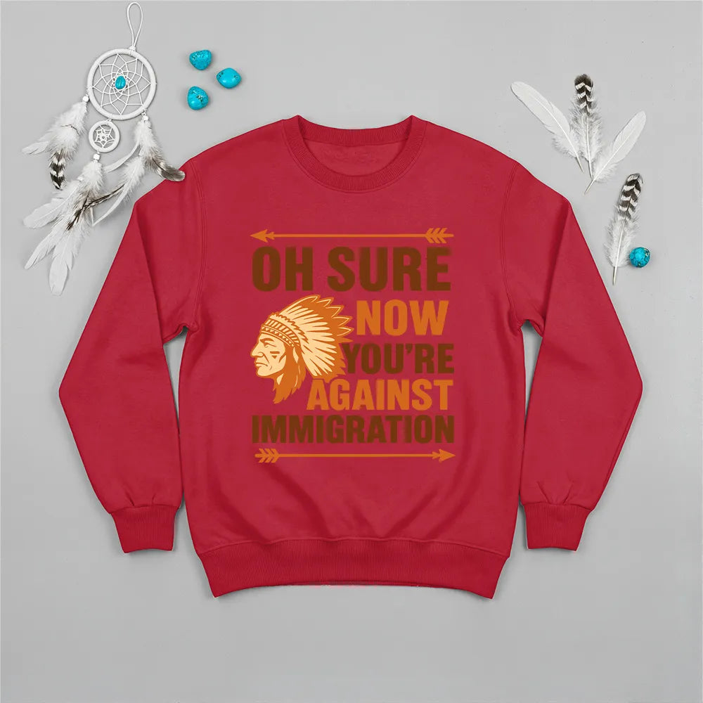 Native America graphic green sweatshirt with traditional chief headgear and 'Oh Sure Now You’re Against Immigration' text."