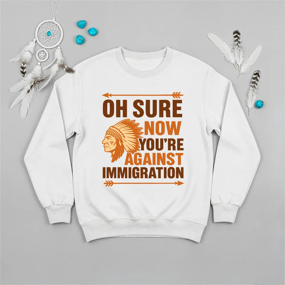 Native America graphic white sweatshirt with traditional chief headgear and 'Oh Sure Now You’re Against Immigration' text.