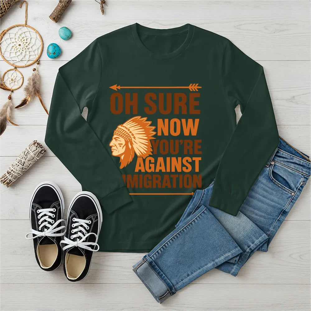 "Native American long sleeve tee with bold 'Now You’re Against Immigration' slogan."