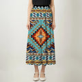 Front view of an asymmetrical maxi skirt with Native American Southwest Navajo-inspired geometric tribal patterns and a teal and black waistband.