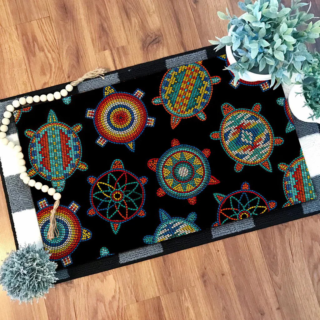 Outdoor doormat with vibrant Native American turtle patterns in bright colors on a black background, placed in front of a wooden door.