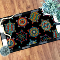 Indoor doormat showcasing colorful Native American turtle designs on black, decorated with plants and home accessories.