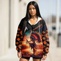 Woman wearing a pullover hoodie featuring a Native American dancer at sunset, with “Native Pride” text and vibrant tribal patterns on sleeves.