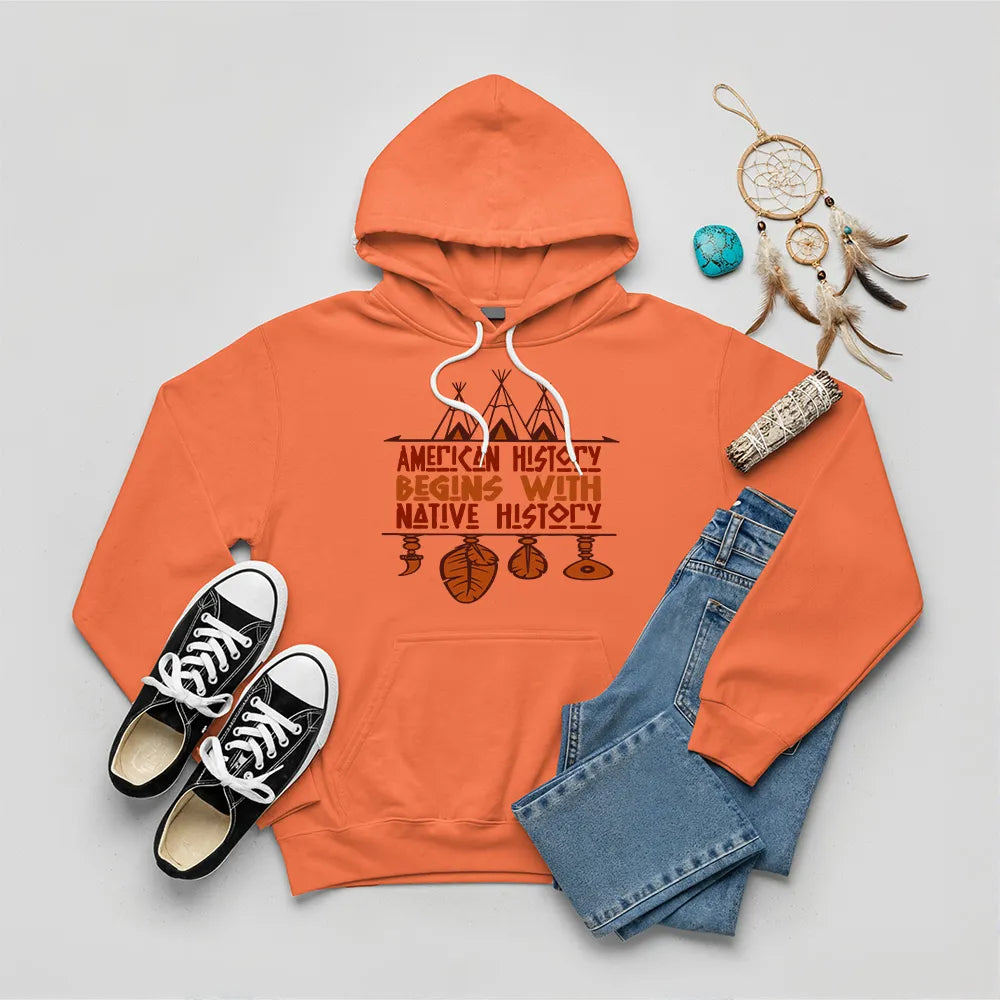 Orange hoodie featuring brown teepee and feather totem graphic with quote “American History Begins with Native History.
