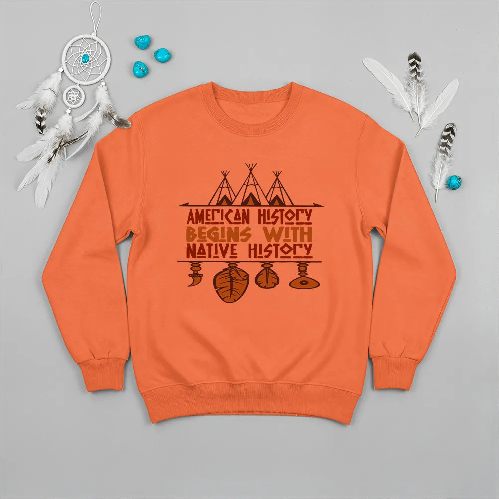 Orange crewneck sweatshirt featuring a sacred teepee and feather totem design with the quote “American History Begins with Native History.