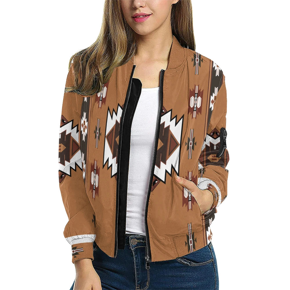 A female model wearing the Southwest Native American Patterned Bomber Jacket, featuring a tan base with bold white and brown tribal motifs arranged in vertical symmetry, complemented by arrow and totem-inspired symbols along the sleeves.