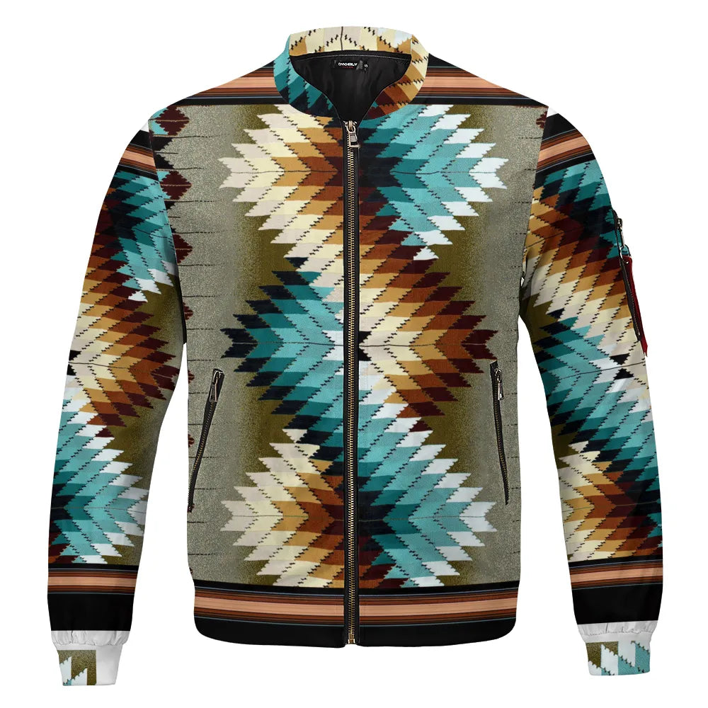A flat lay of the Tribal Spirit Bomber Jacket showcasing bold, jagged Southwestern geometric patterns in teal, ivory, rust, and black against a muted olive-green backdrop, finished with black trim and a front zipper.