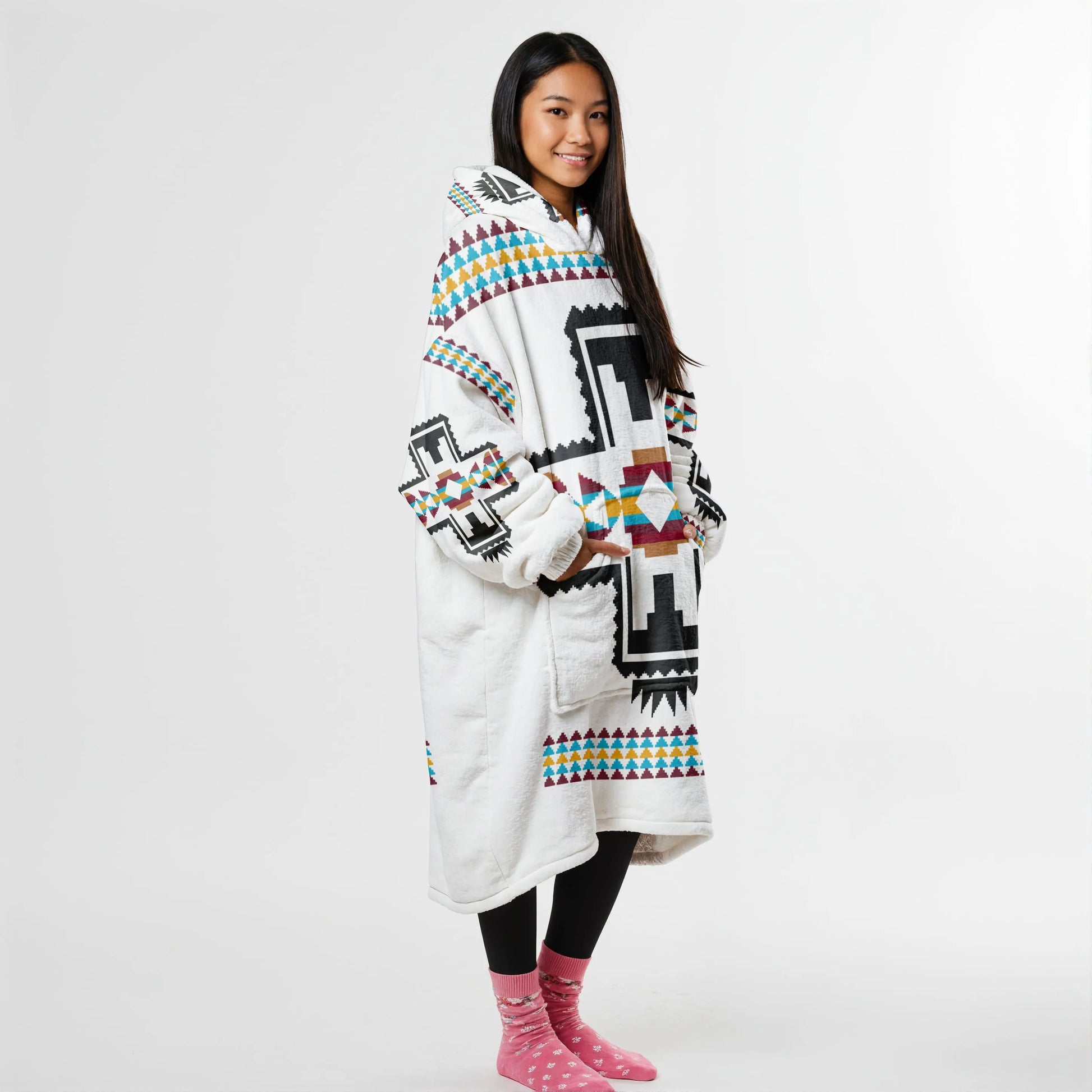 Side view of a person in a white wearable blanket hoodie featuring black buffalo prints and tribal accents, perfect for lounging or outdoor chill