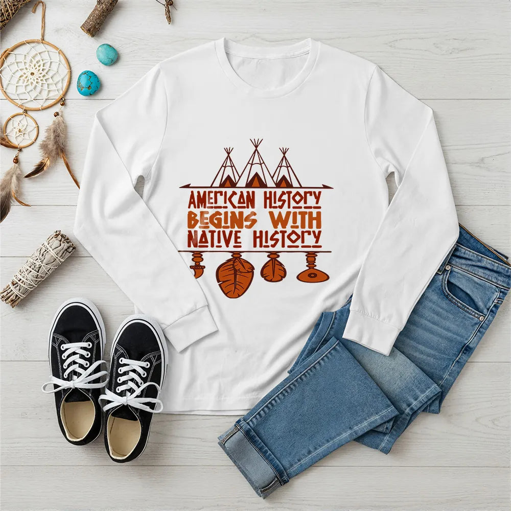 White long sleeve tee featuring brown teepee and feather totem graphic with quote “American History Begins with Native History