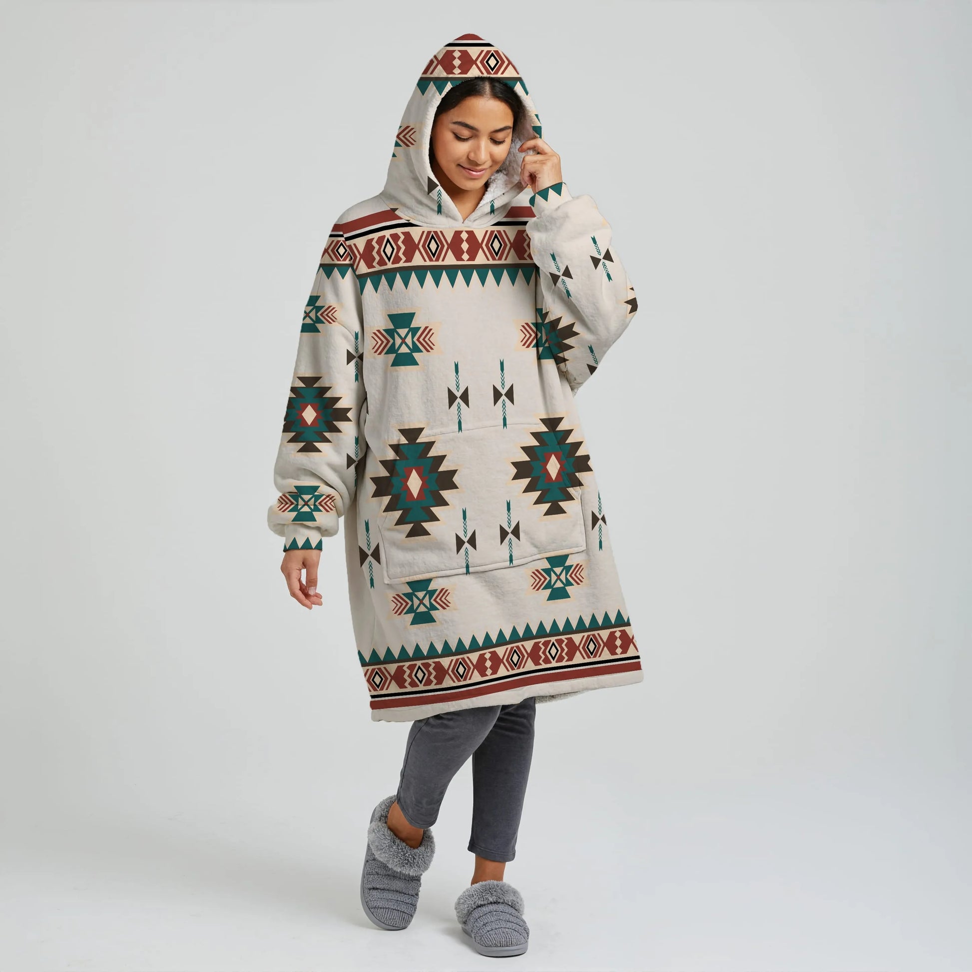 Female model wearing a cream Southwestern tribal snug-up hoodie with fully expanded sleeves, kangaroo pocket, and oversized wearable blanket design