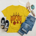 Yellow t-shirt displaying brown teepee and feather totem graphic with quote “American History Begins with Native History