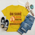 Yellow t‑shirt featuring brown chief headdress graphic and text “Oh Sure Now Youre Against Immigration.”