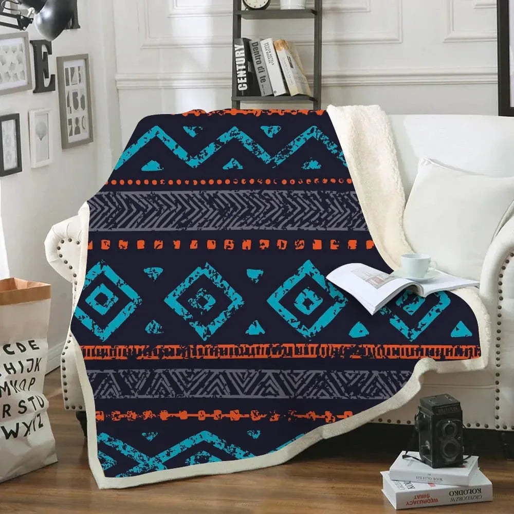Great Basin Native American tribal sherpa blanket with distressed blue and orange geometric patterns draped on a white sofa