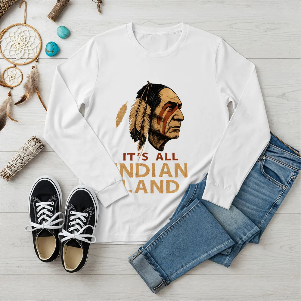 A white long sleeve t-shirt displaying a Native American headdress graphic and the "It’s All Indian Land" quote.
