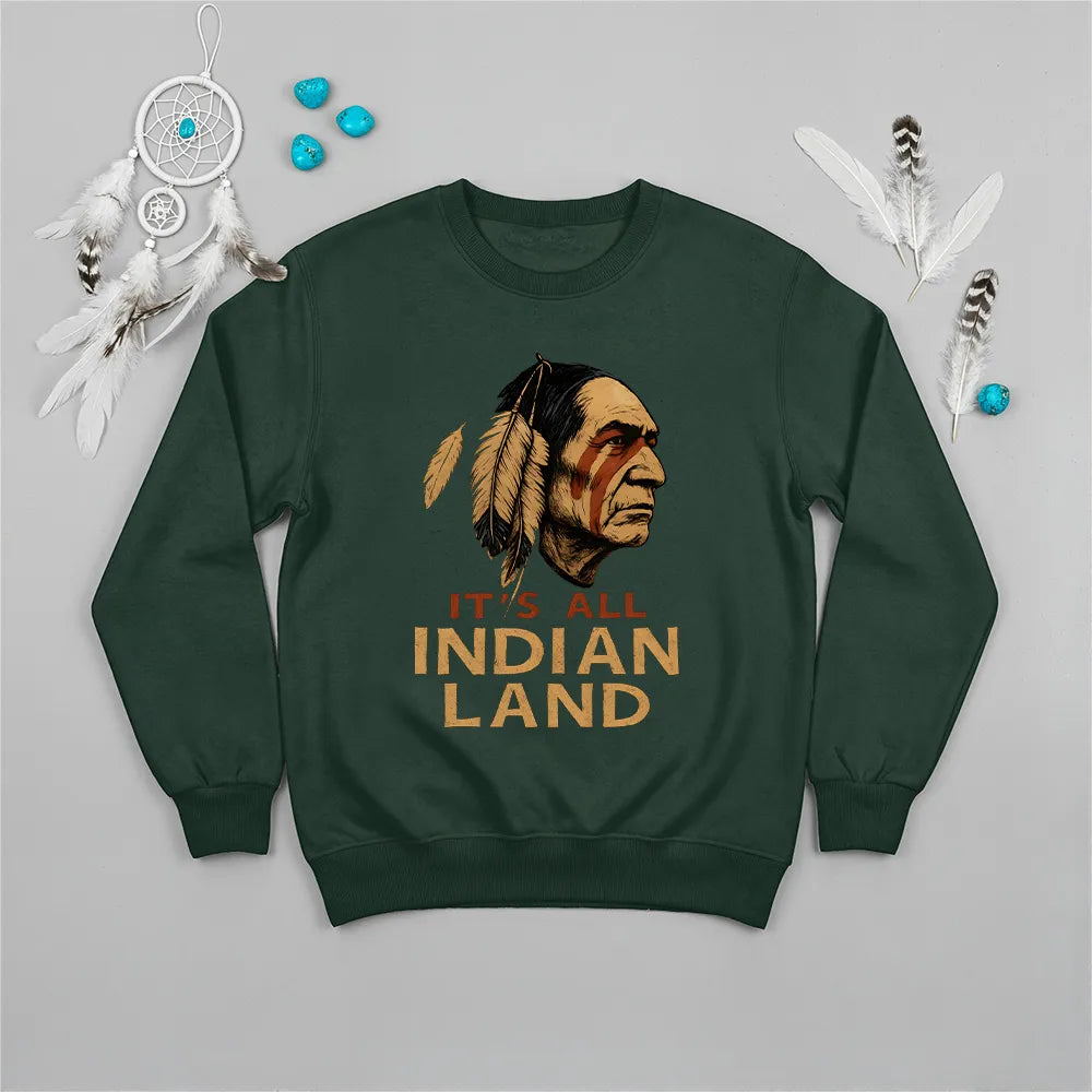 A forest green sweatshirt displaying the "It’s All Indian Land" slogan and detailed Native American headdress.