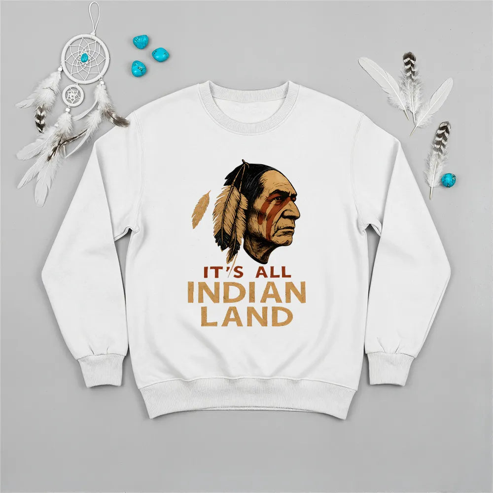 A white sweatshirt displaying a Native American headdress graphic and the "It’s All Indian Land" quote.