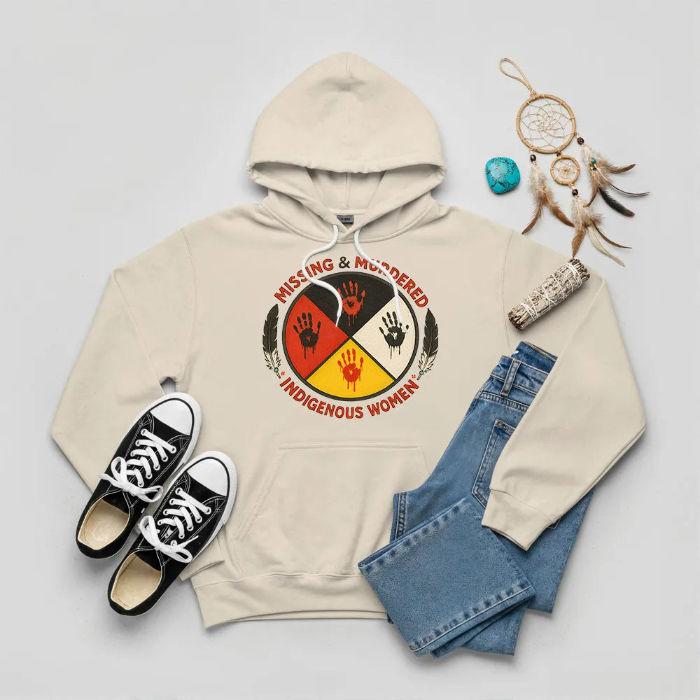 A beige hoodie with the "Missing & Murdered Indigenous Women" graphic, laid flat with relevant accessories.