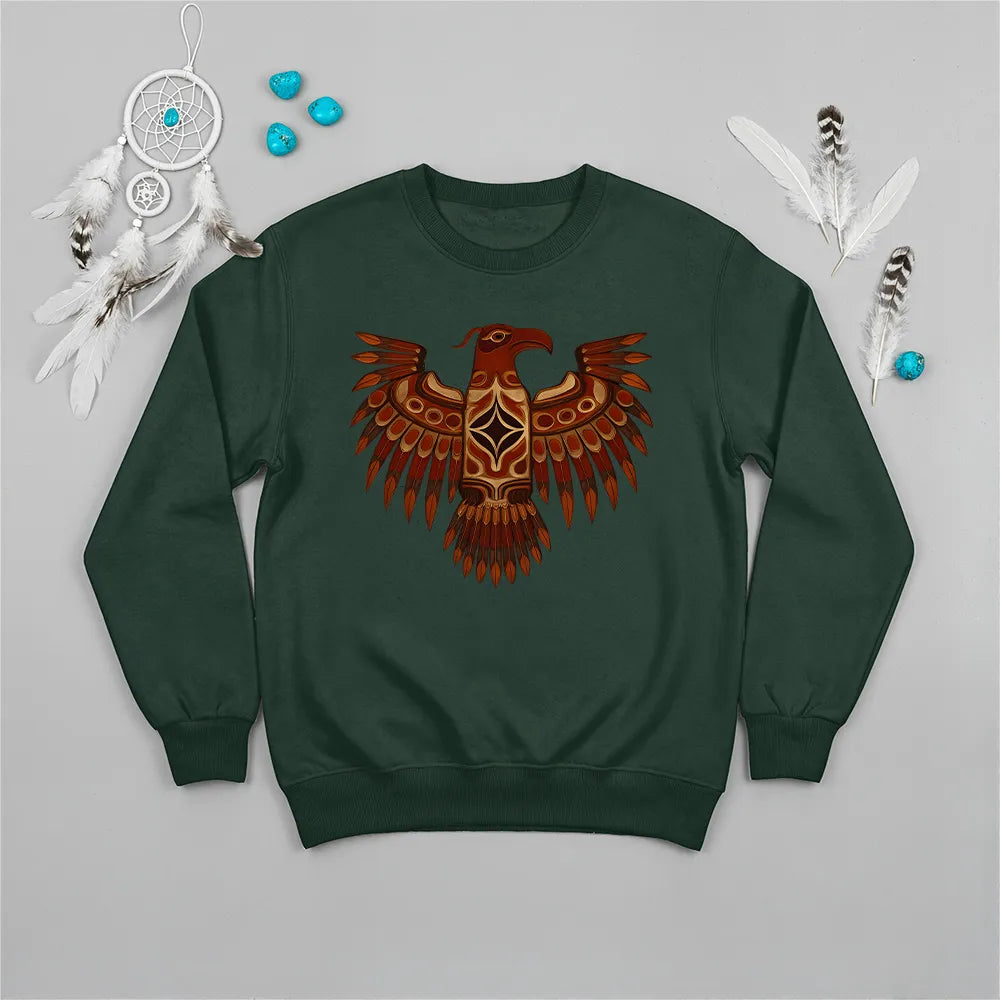 A forest green crewneck sweatshirt with an indigenous-inspired Thunderbird motif, displayed with native accessories on a grey background.