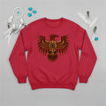 A red crewneck sweatshirt featuring a traditional Native American Thunderbird design, laid flat with a dreamcatcher and feathers.
