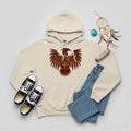 A desert sand hoodie with a Native American Thunderbird totem design, paired with jeans and sneakers.