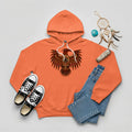 An orange hoodie featuring a striking indigenous Thunderbird pattern, arranged with denim pants and sneakers.