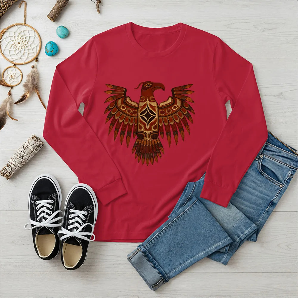 A red long-sleeve t-shirt featuring a traditional Native American Thunderbird design, styled with jeans and sneakers.
