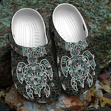 Pair of Native American tribal pattern Crocs sandals on natural outdoor background.