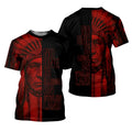 Black crewneck t‑shirt with red geometric details on sleeves and hem; back features a warrior portrait with the message “No One Is Illegal on Stolen Land.”