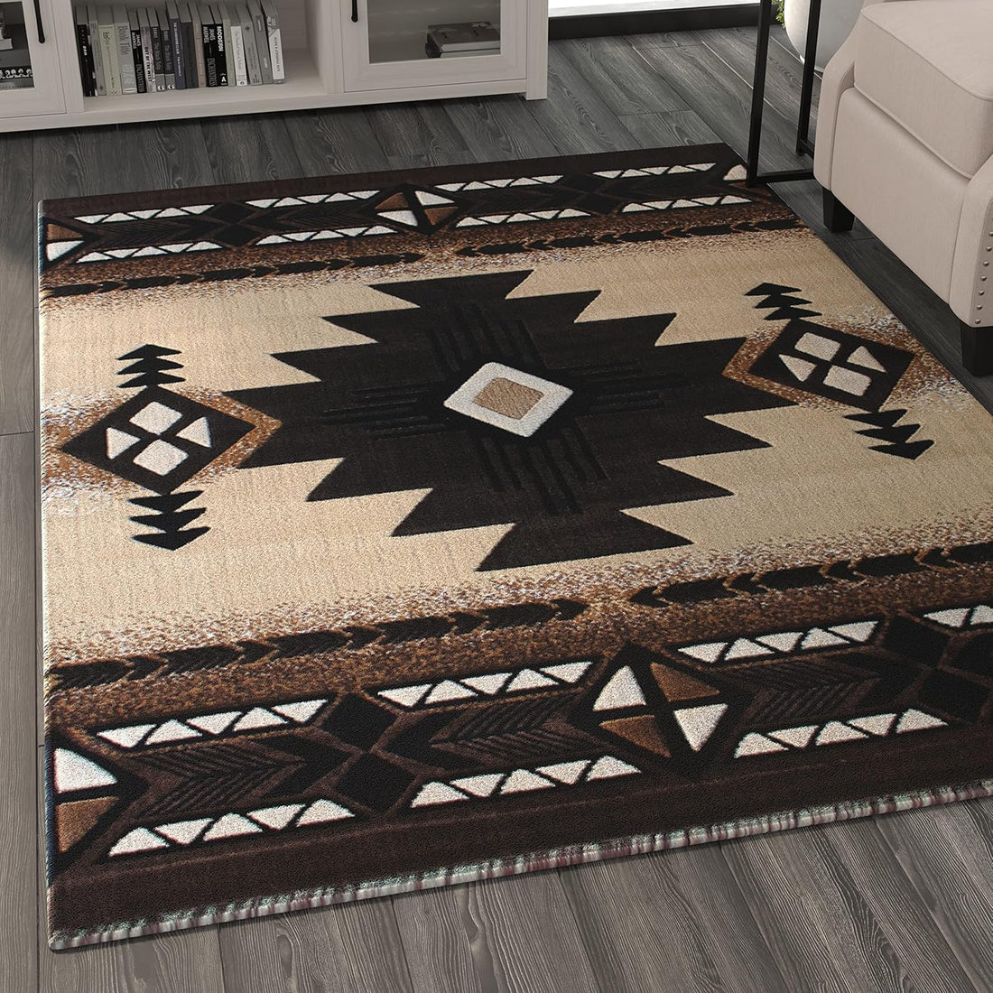 A contemporary living room scene showing an angled view of a black-and-beige Southwest tribal rug with bold geometric patterns beneath a beige armchair and side table.