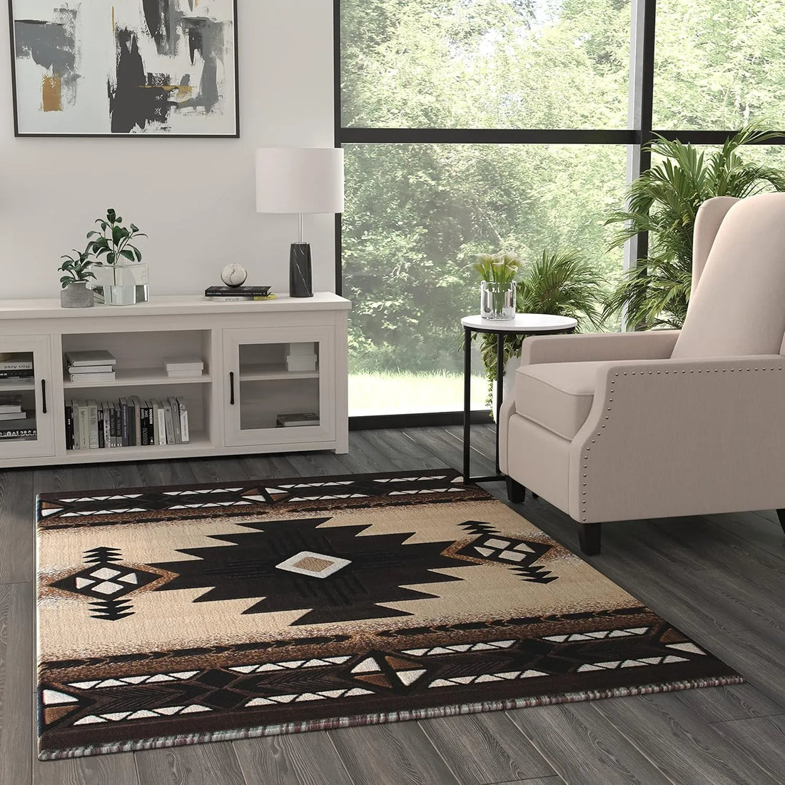 A contemporary living room scene showing an angled view of a black-and-beige Southwest tribal rug with bold geometric patterns beneath a beige armchair and side table.