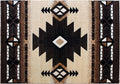 Close-up angled shot of a black-and-beige Southwest tribal rug, highlighting its central diamond motif and surrounding triangular border design.