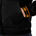Close-up of Native-inspired tribal patterns in golden tones on hoodie sleeves and hood
